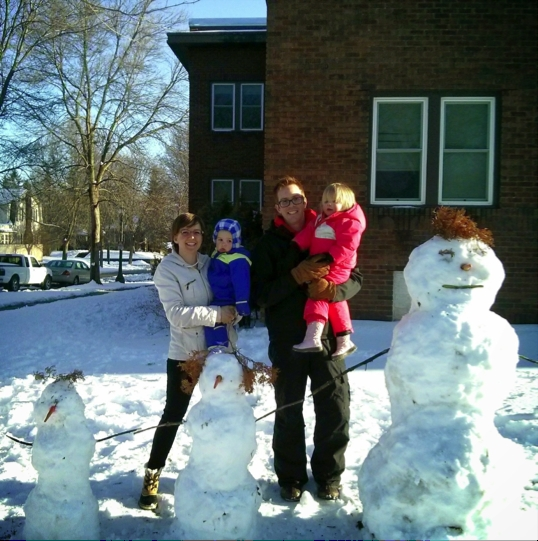 Family Posing with their Snowman