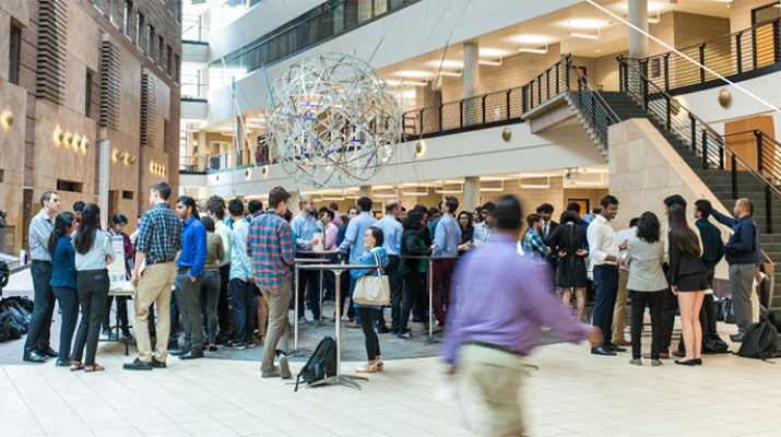 Carlson School Atrium with many students standing in groups talking