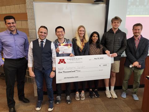 The Hackathon winning team poses with a check and members of the Minnesota Department of Human Services.