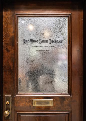 Wood door with Red Wing Shoe COmpany Manufacturers imprinted on it.