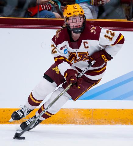 Grace Zuwinkle skates on the ice while handling the puck during a Gophers hockey game.