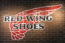 Red Wing Shoes logo on a brick wall.