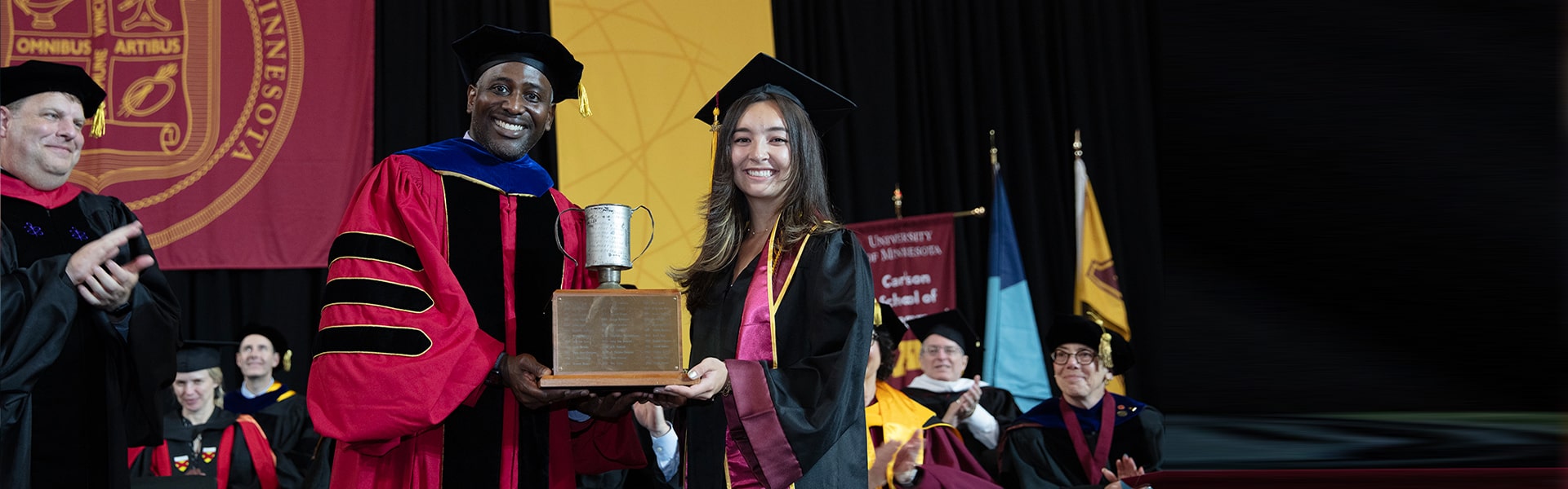 Brynn Nguyen and Assistant Dean Nicholas Wallace holding the Tomato Can Loving Cup award.