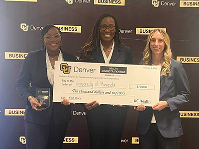 Three students holding oversized check after winning case competition