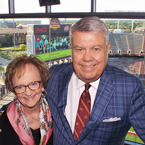 Jim Campbell, ’64 BSB, a former Carlson School dean and wife, Carmen, pose together in suite at Huntington Bank Stadium.