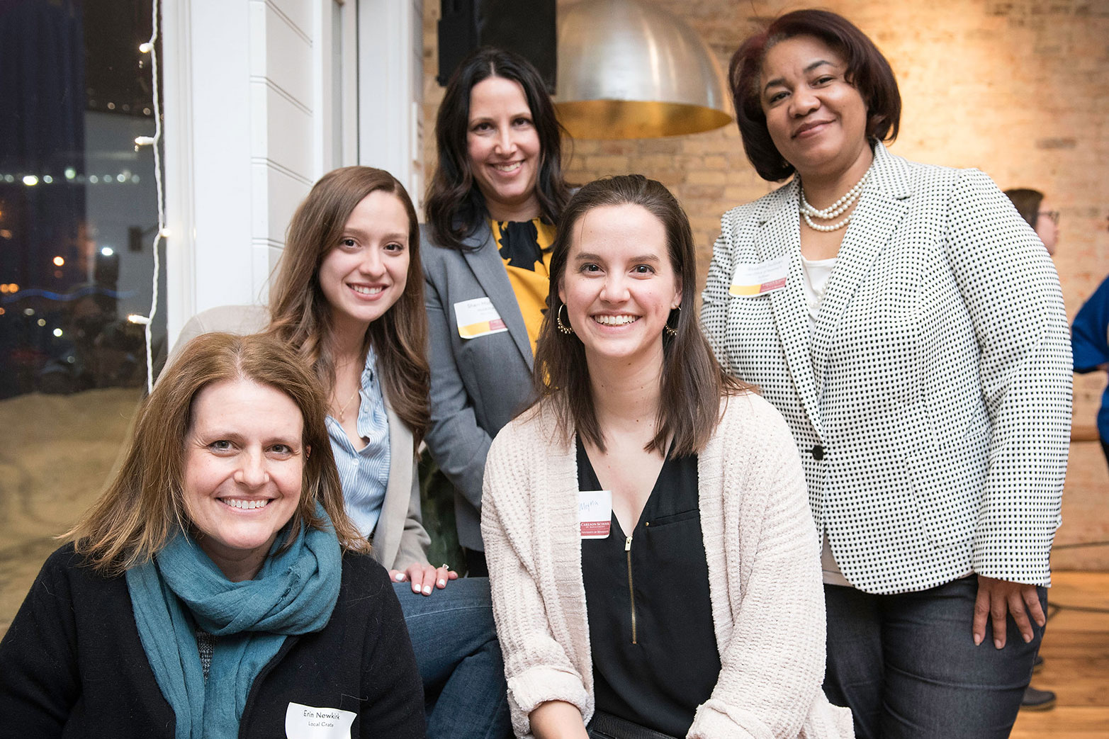 Five alum from the Carlson School of Management pose for a picture at a Carlson Women Connect event.