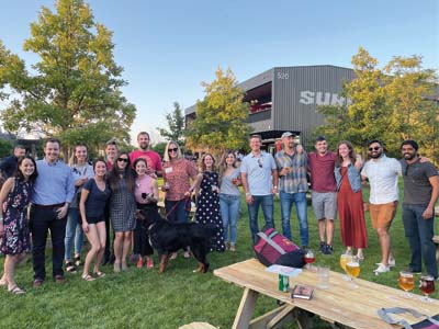 People pose for a group photo near picnic table at Surly Brewing Company