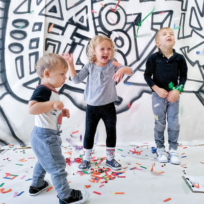 Toddlers play with colorful confetti.