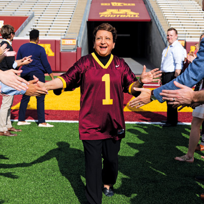 Sri Zaheer high fives people as she comes out of a football tunnel at TCF Bank Stadium.