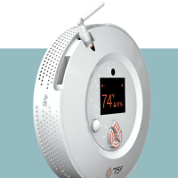 A white circular device that monitors building air temperature controls.