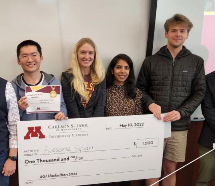 Winners of inaugural Analytics for Good Hackathon with giant check.
