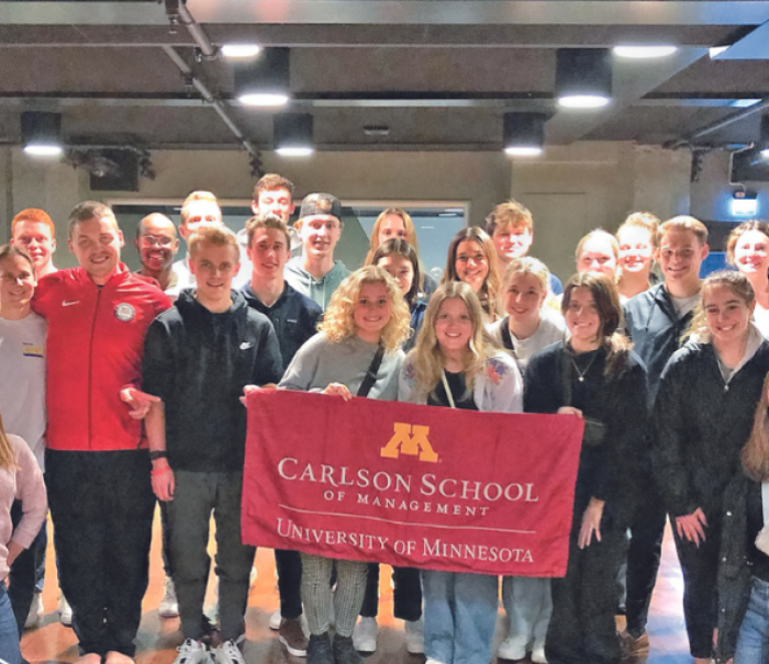 Group photo of Carlson School students holding Carlson School banner.