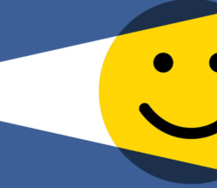 An illustration of a light shining on a smiley face