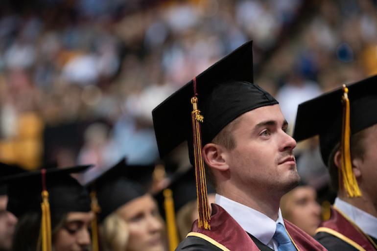 Graduate listening intently during Commencement ceremony 