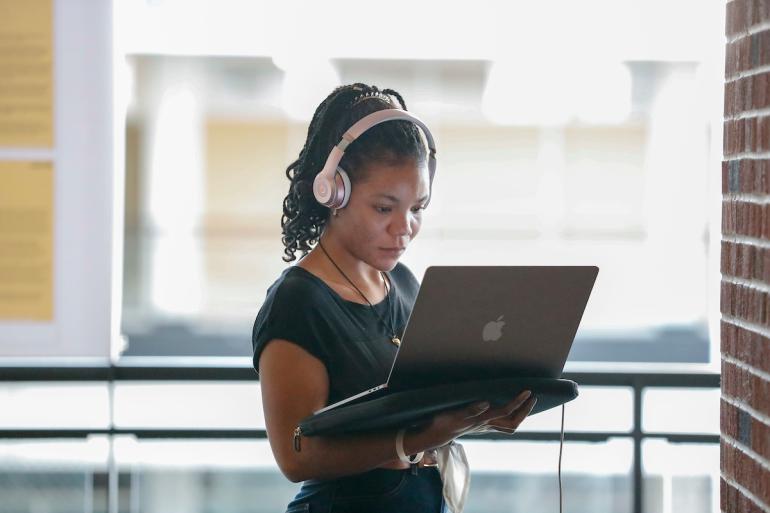 A person wearing headphones and using a computer