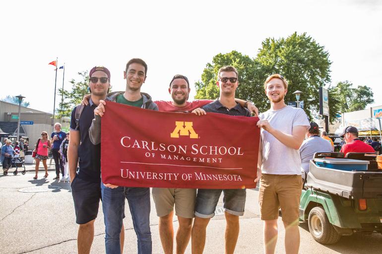 Group of students holding a Carlson School of Management banner