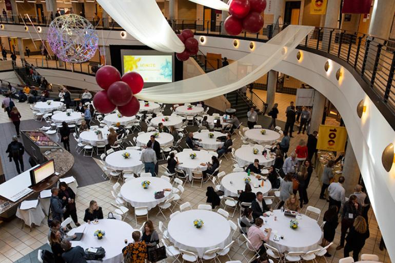 Overhead shot of many tables and balloons set up in Carlson School atrium for the 2019 Ignite Conference