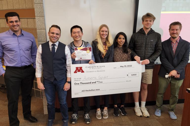 The Hackathon winning team poses with a check and members of the Minnesota Department of Human Services.