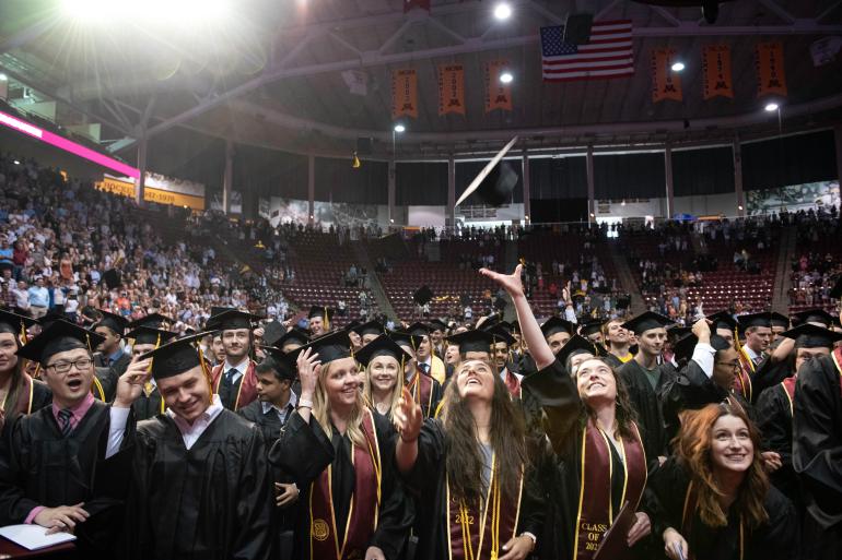 Undergraduates throw caps at the 2022 commencement ceremony.