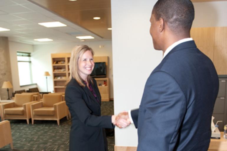 A student and interviewer handshaking before an on-campus interview