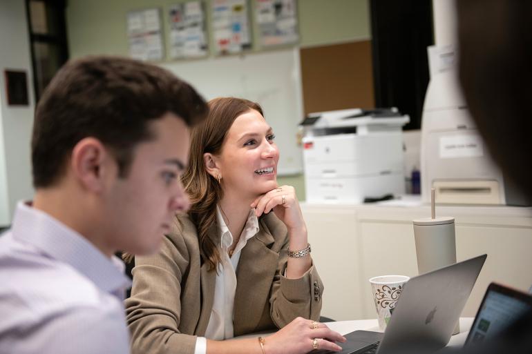 Two colleagues in an office setting, focusing on their work.