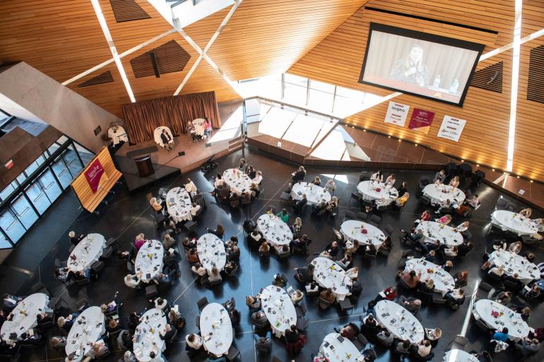 Group of tables and guests in McNamara Alumni Center