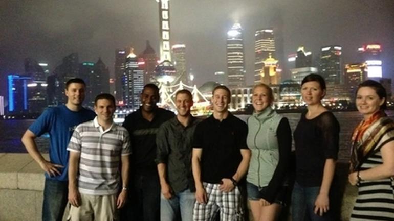 Group Posed in Front of Beijing Skyline at Night 