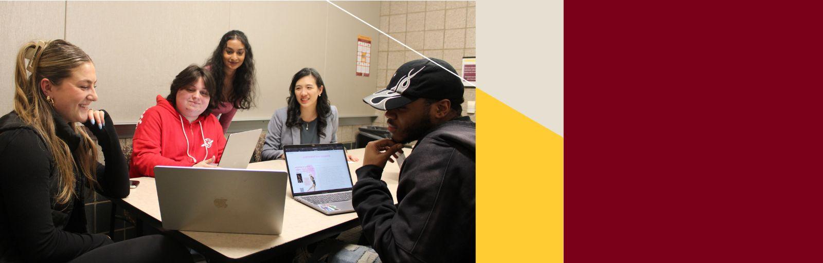Students collaborate on a project while receiving feedback from a professor.