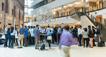 Carlson School Atrium with many students standing in groups talking