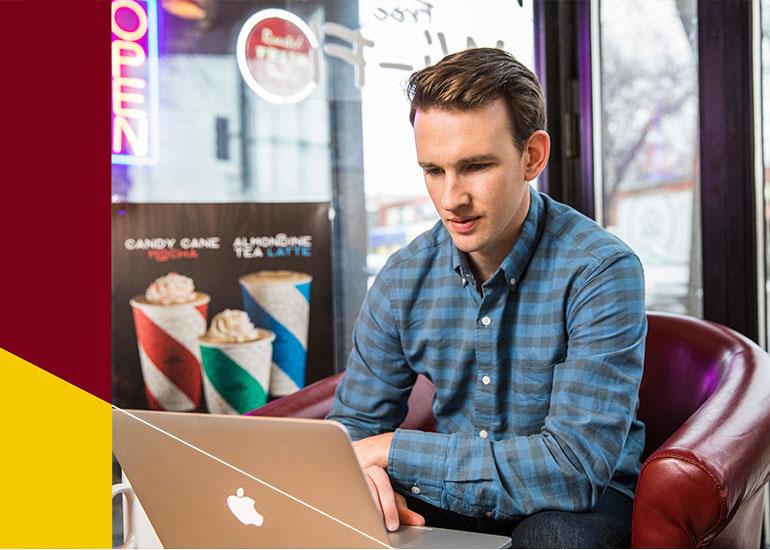 Medical industry graduate certificate student sitting in coffee shop with laptop