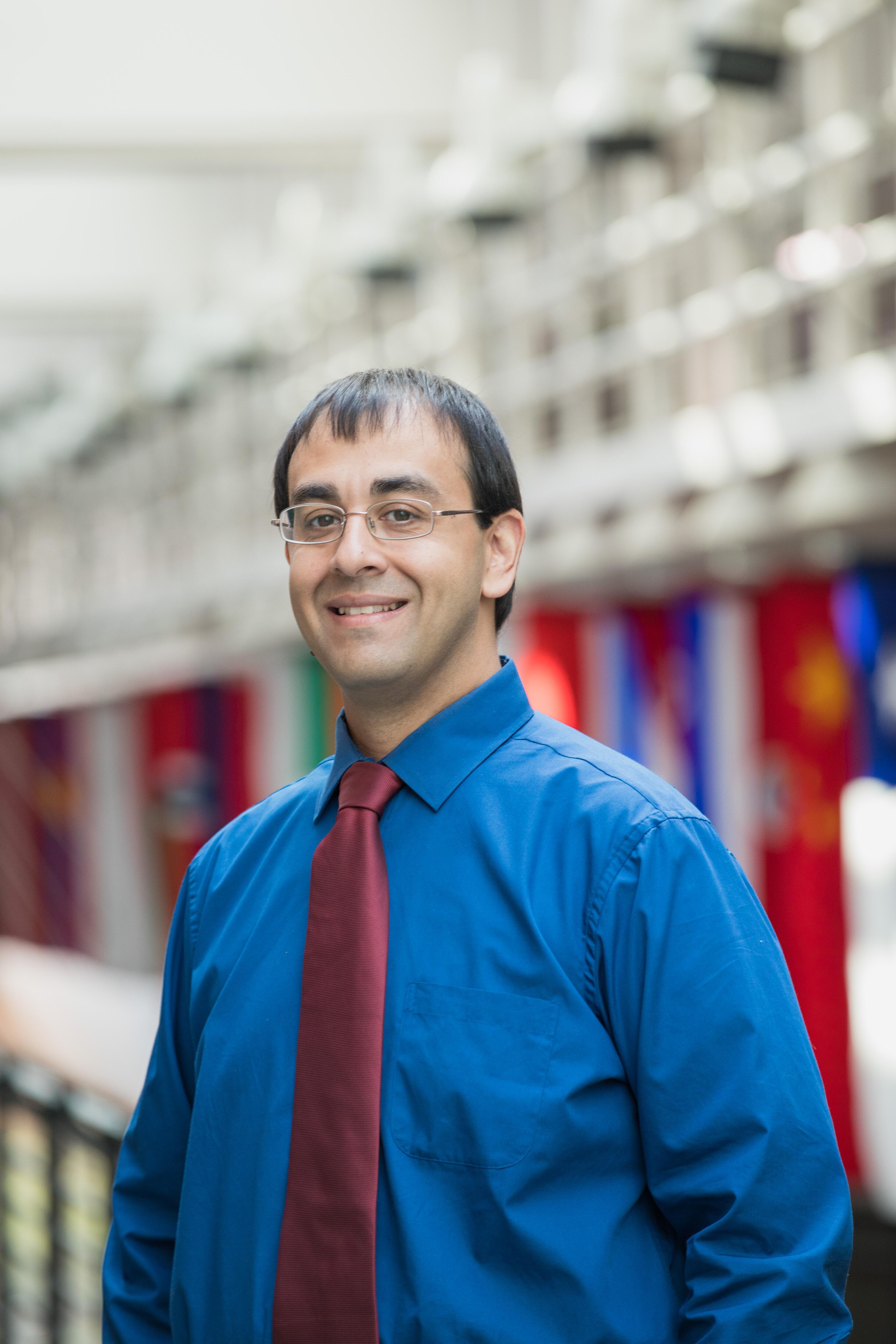 Andy Ramdular in front of flags from around the world.