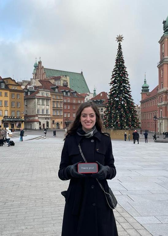 Callie Stevermer standing in an empty town square with a large Christmas tree in the background.