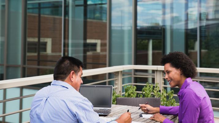 Business Professionals smiling and working around a table