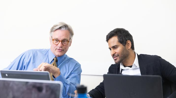 Business leaders discussing data on laptop computers