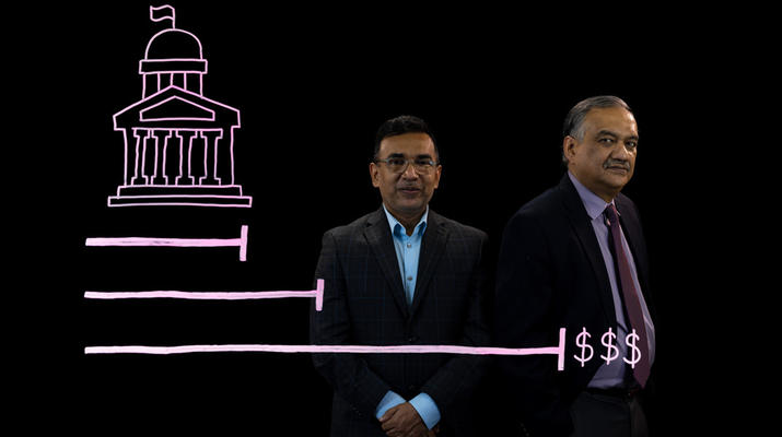 Anant Mishra and Kinghuk Sinha stand behind an illustration of a government building and a bar graph with growing dollar amounts.