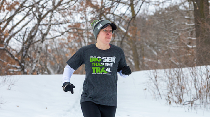 Mindy Bahr running through snow in woods