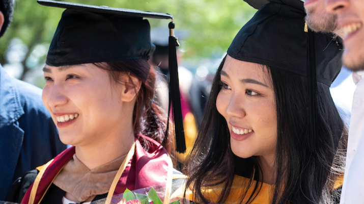 Two students in cap and gown during Commencement 