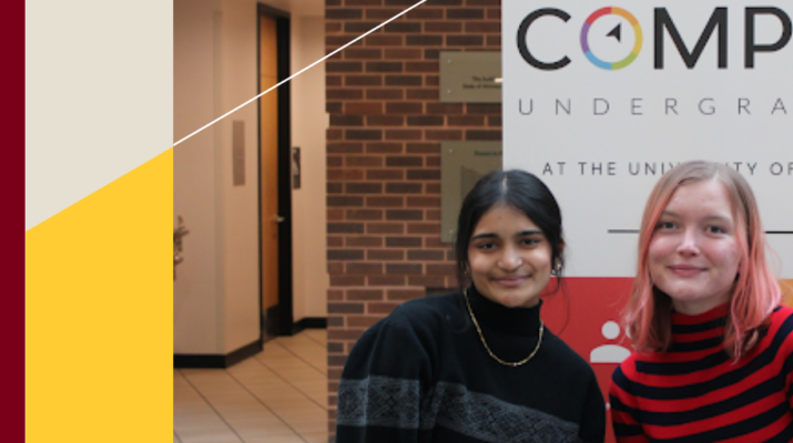 Two students sit in front of a sign promoting the Compass student organization.