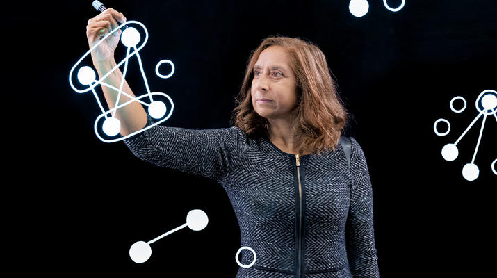 Associate Professor Pri Shah in front of black screen drawing with a light pen