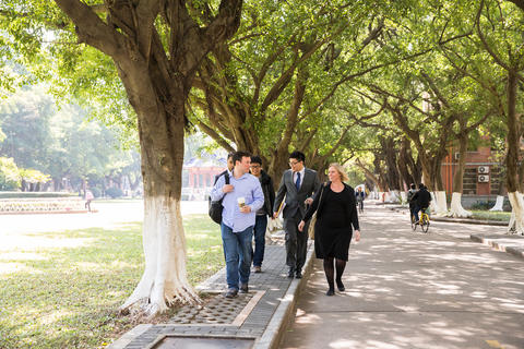 Five young professionals walking and talking in Guangzhou, China.