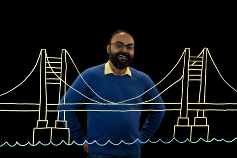 Sunasir Dutta stands behind an illustration of a bridge