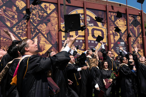 Graduates toss caps outside following the 2022 commencement ceremony