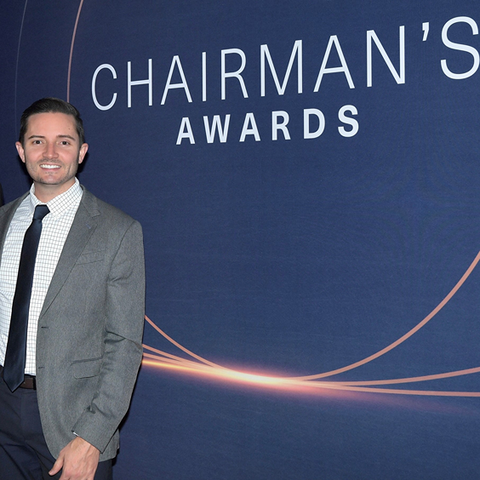 Robert Shields standing next to Chairman's Awards sign