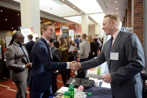 Carlson student shaking hands with corporate recruiter at Career Fair.