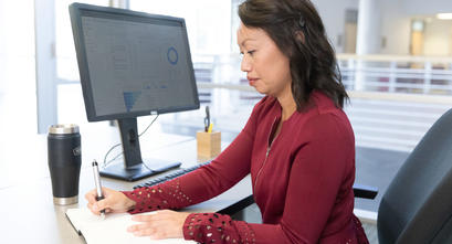 Digital marketing leader taking notes at a computer