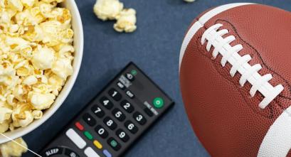 A graphic illustration of a football next to a TV remote and a bowl of popcorn