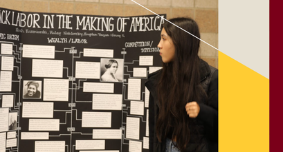 Students look at a poster in the Race, Power, and Justice in Business class.