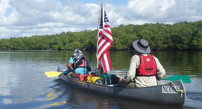 Outward Bound USA participants canoe down a river