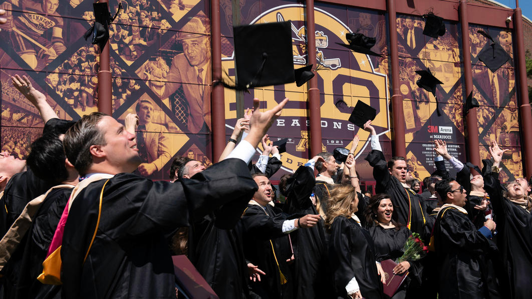 Graduates toss caps outside following the 2022 commencement ceremony