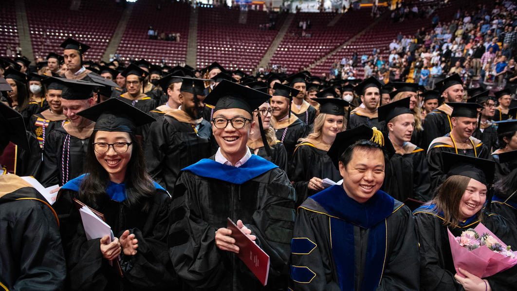 Graduate students cheer at the 2022 commencement ceremony
